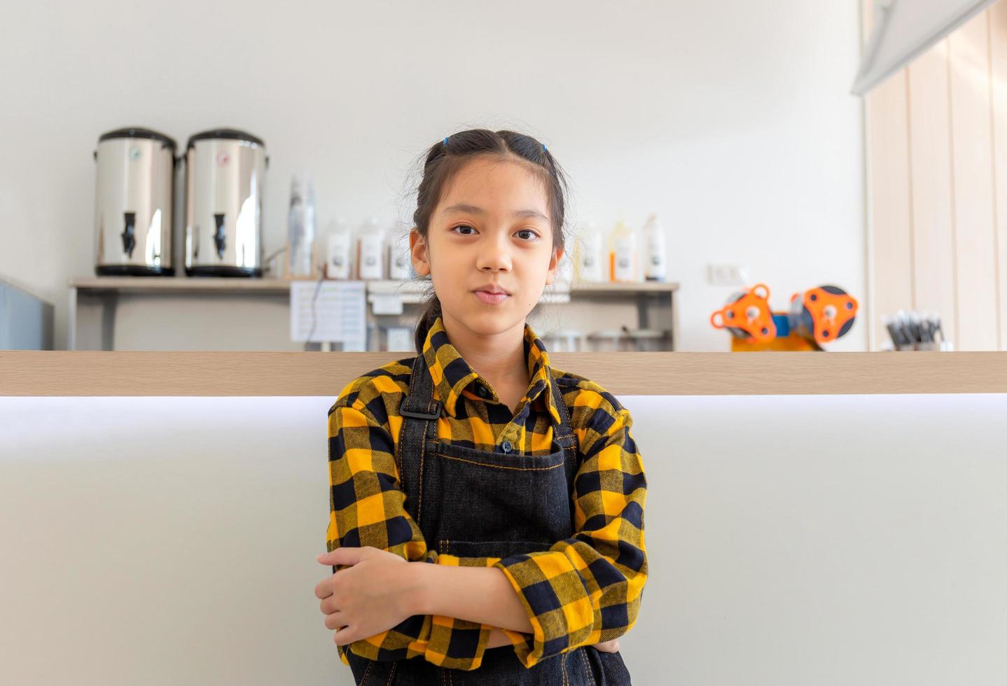 Asian little girl wearing apron happy face smiling with crossed arms looking at the camera photo