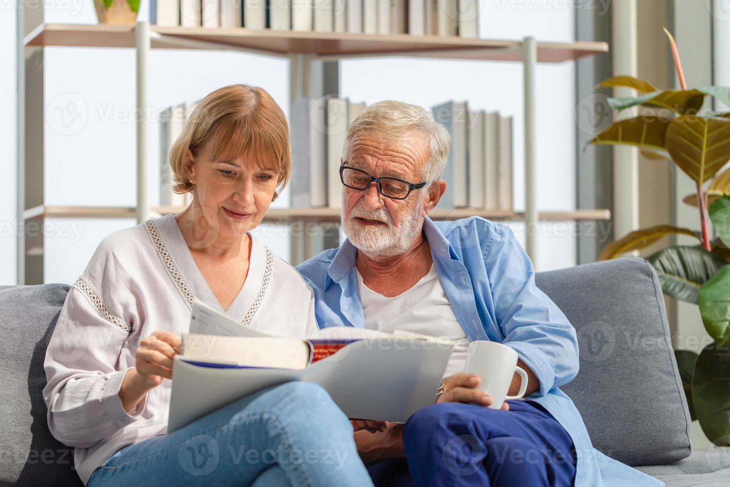 Senior people gadgets in room. Happy elderly couple on sofa in