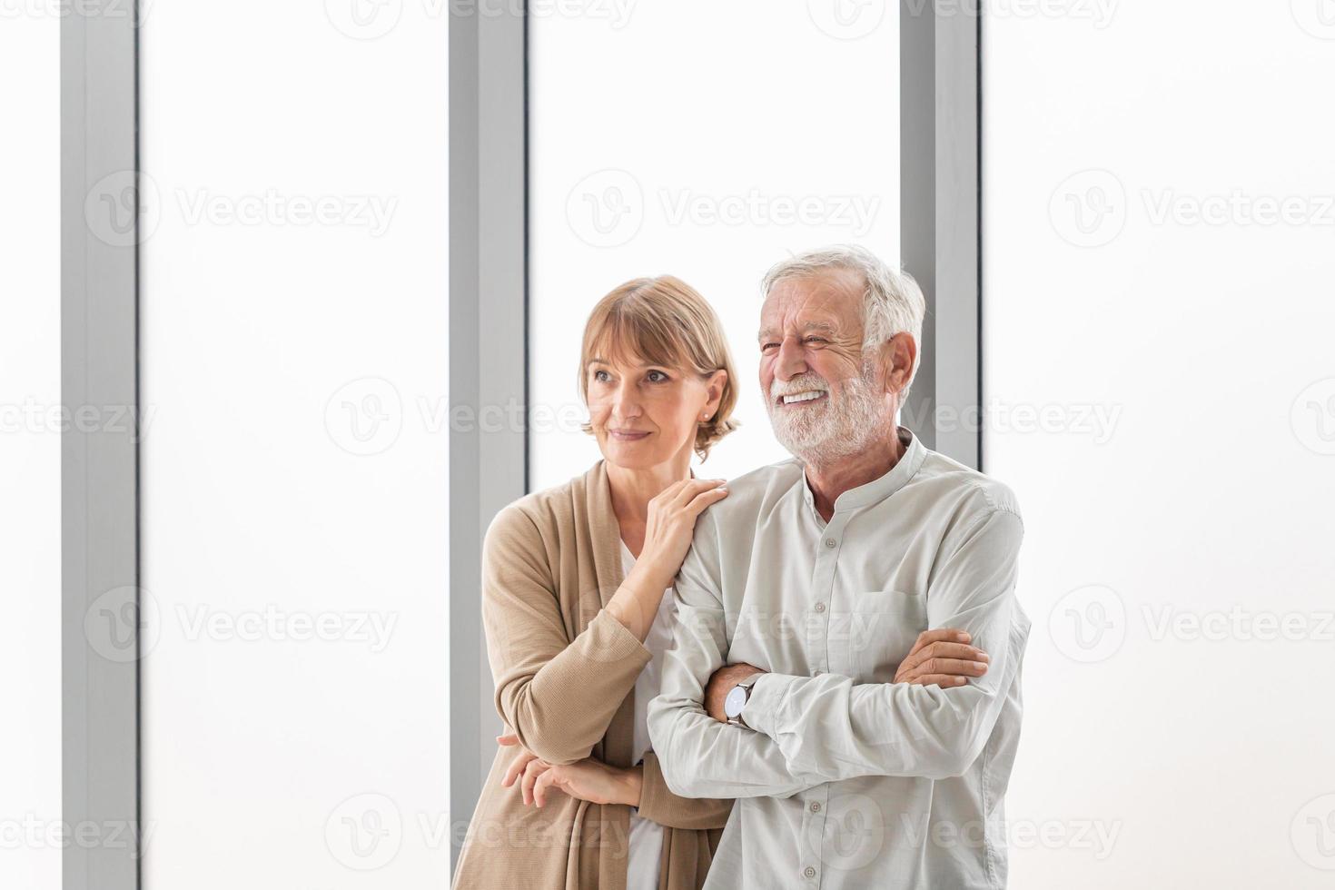 Portrait of Modern senior couple standing in living room, Happy elderly woman and a man photo