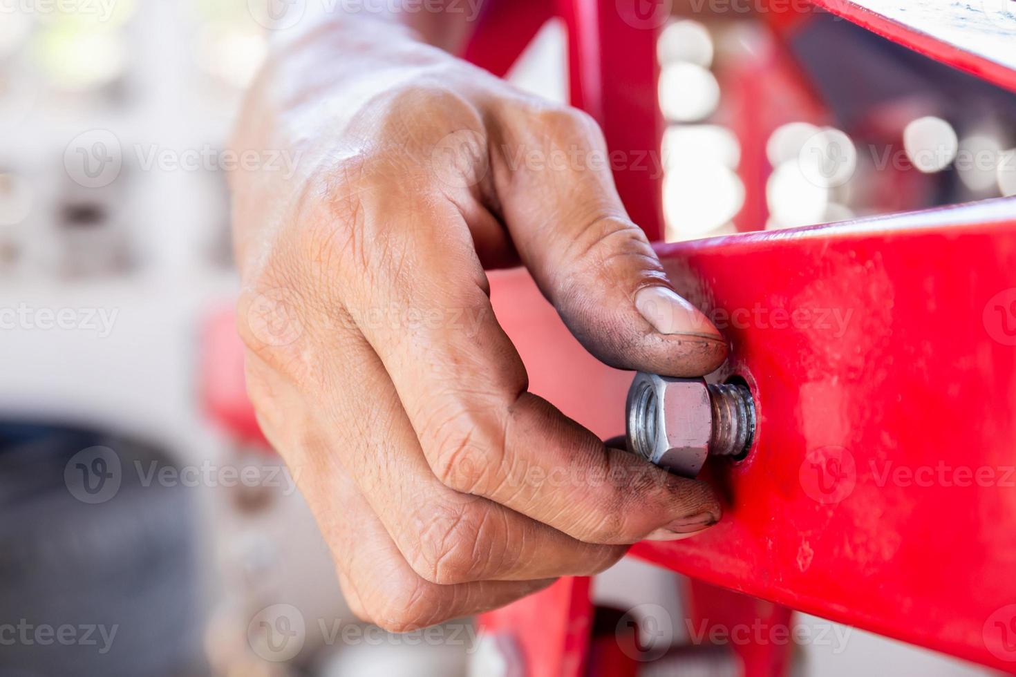 Close up of repair mechanic hands install bolts and nuts of piping, Worker's hand tightens the nut on the bolt photo