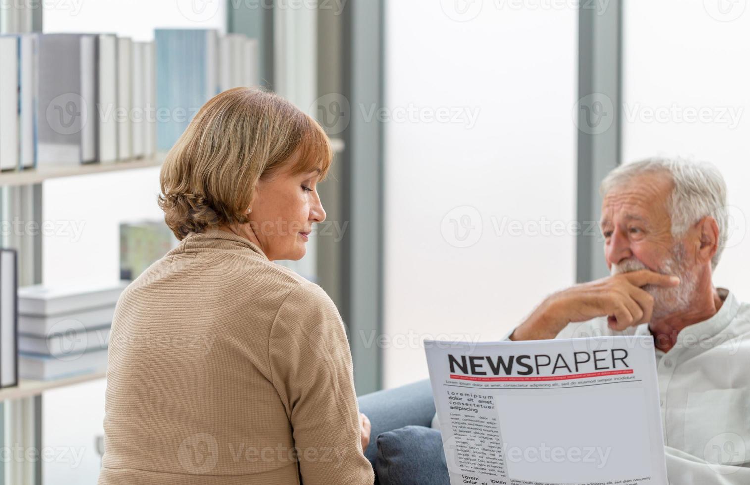 retrato de una pareja mayor en la sala de estar, una anciana y un hombre leyendo un periódico en un acogedor sofá en casa, conceptos familiares foto