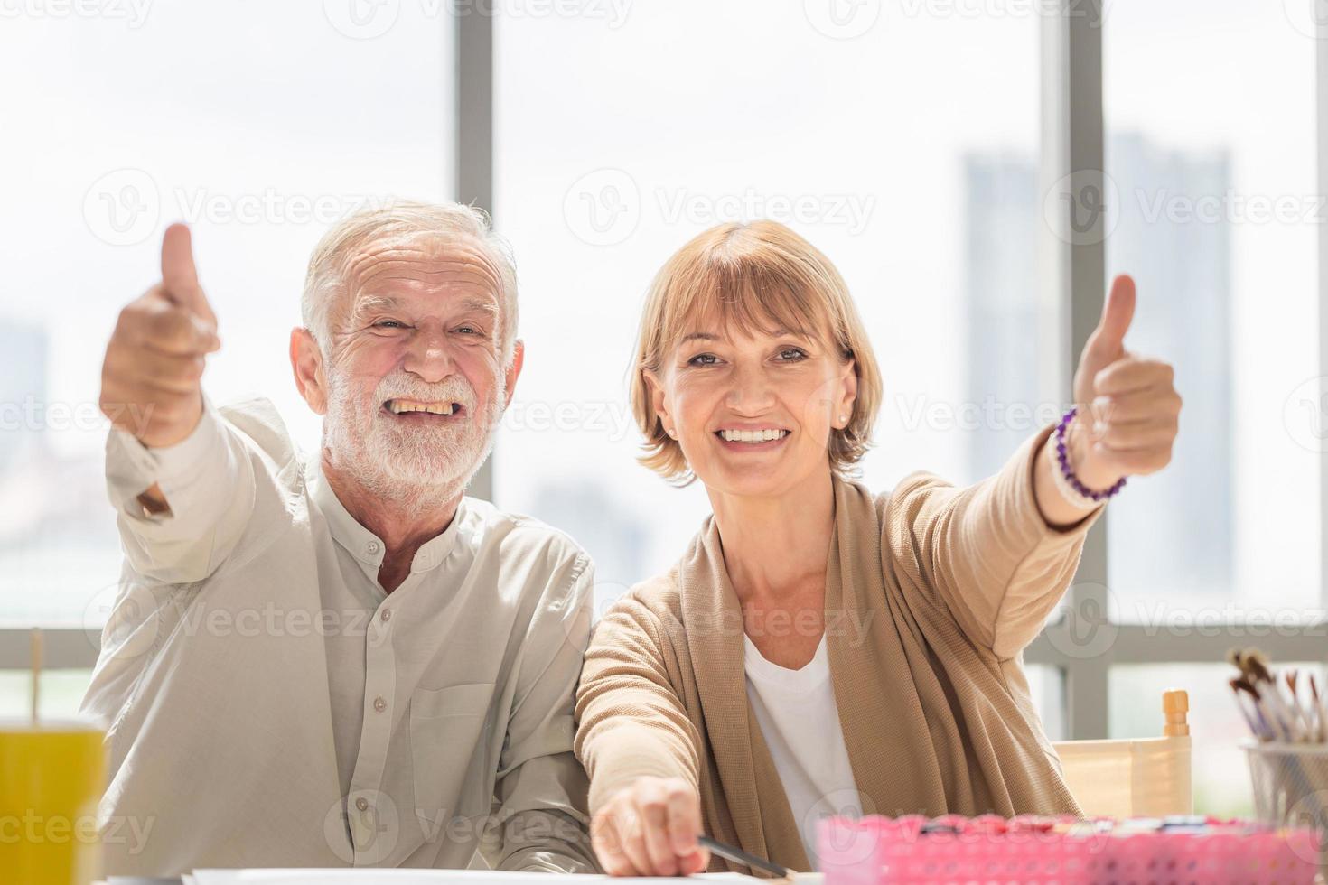 Happy senior couple in workshop at art studio, Smiling elderly couple with showing thumbs up photo