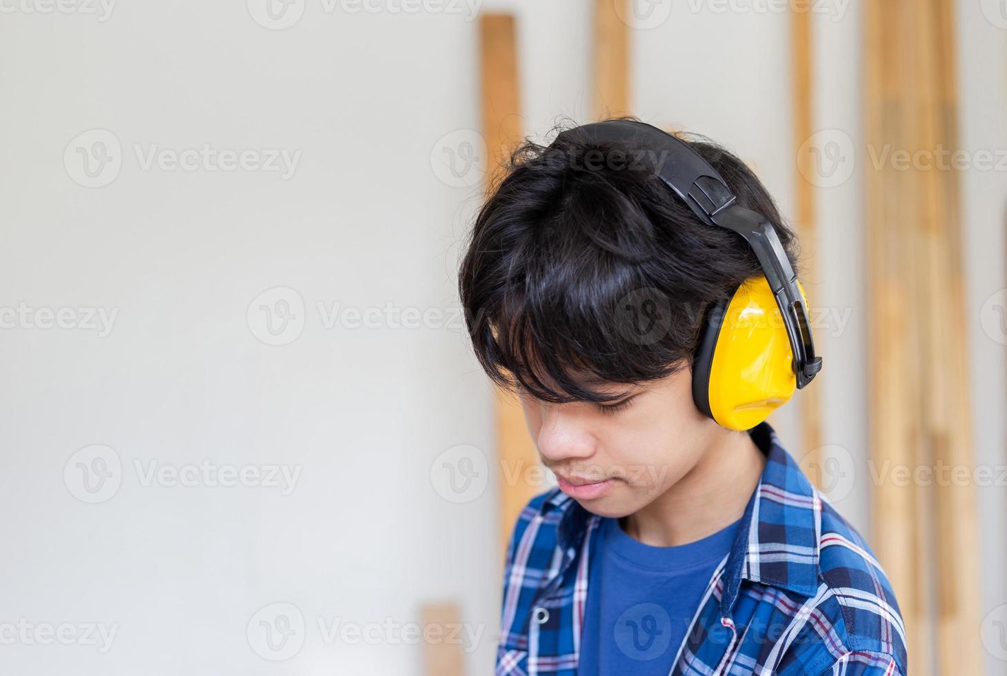 niño de pie con orejeras de reducción de ruido en un taller de carpintería.  niño aprendiendo en el taller del artesano 6848195 Foto de stock en Vecteezy