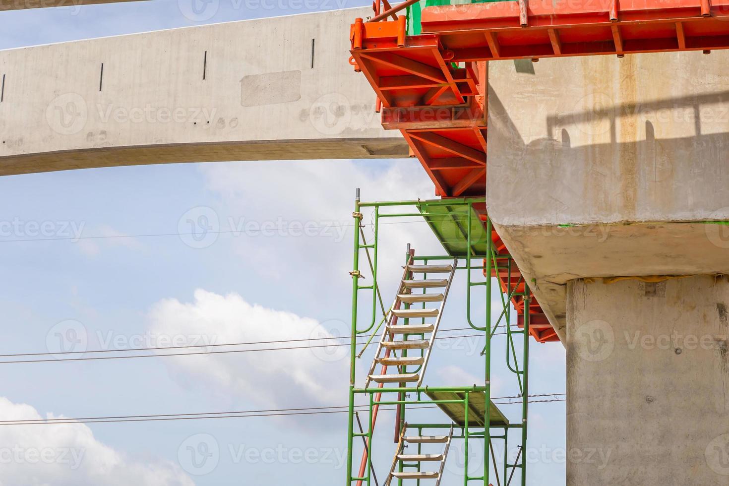 Stairs and scaffolding structures at construction of a mass transit train line in progress with heavy infrastructure photo