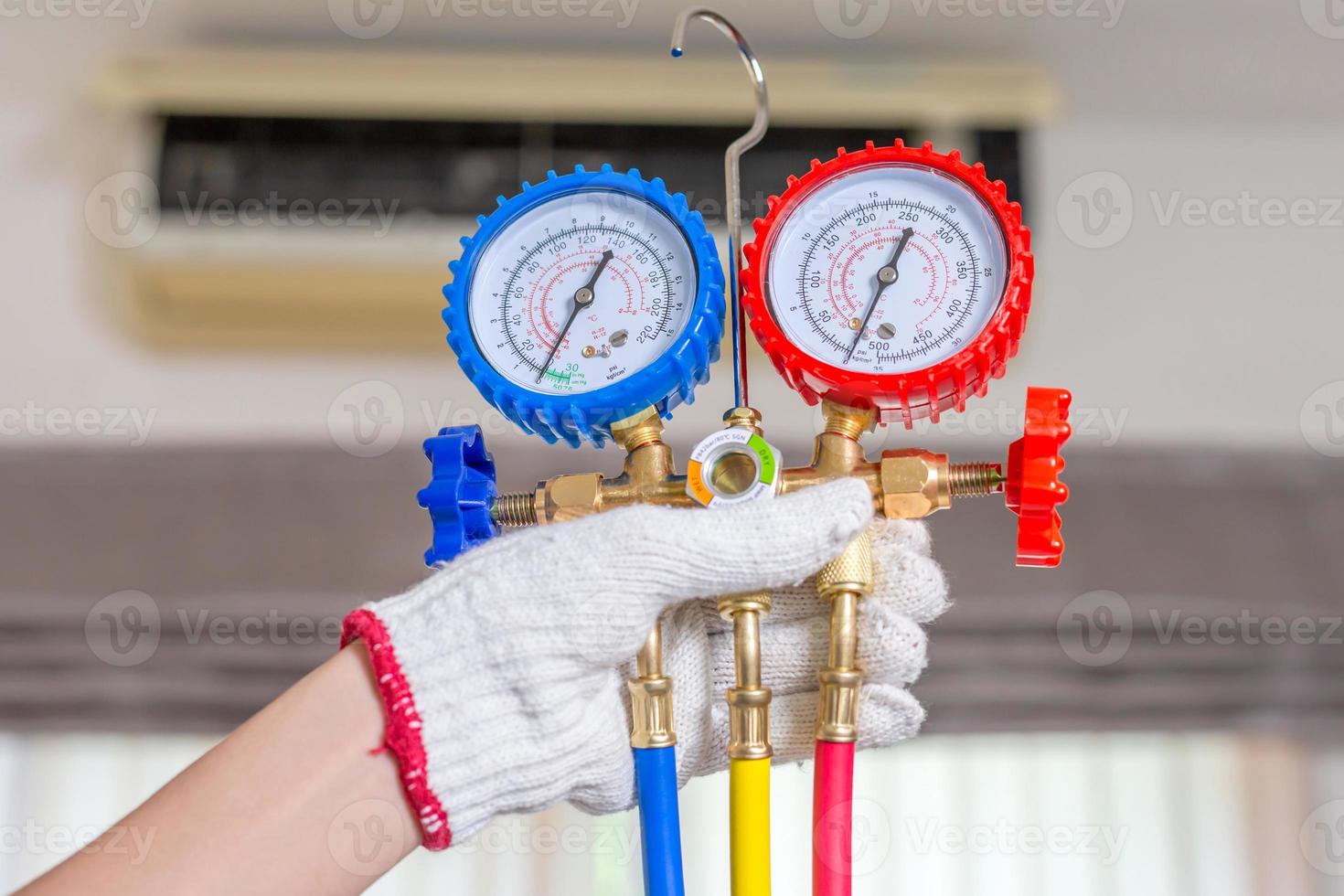 Air Conditioning Repair, repairman holding monitor tool to check and fixed air conditioner system photo