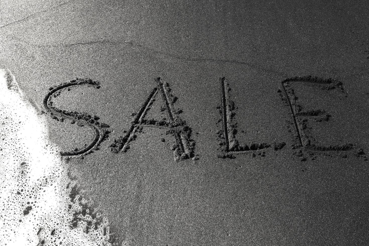 inscription sale on the black sand photo