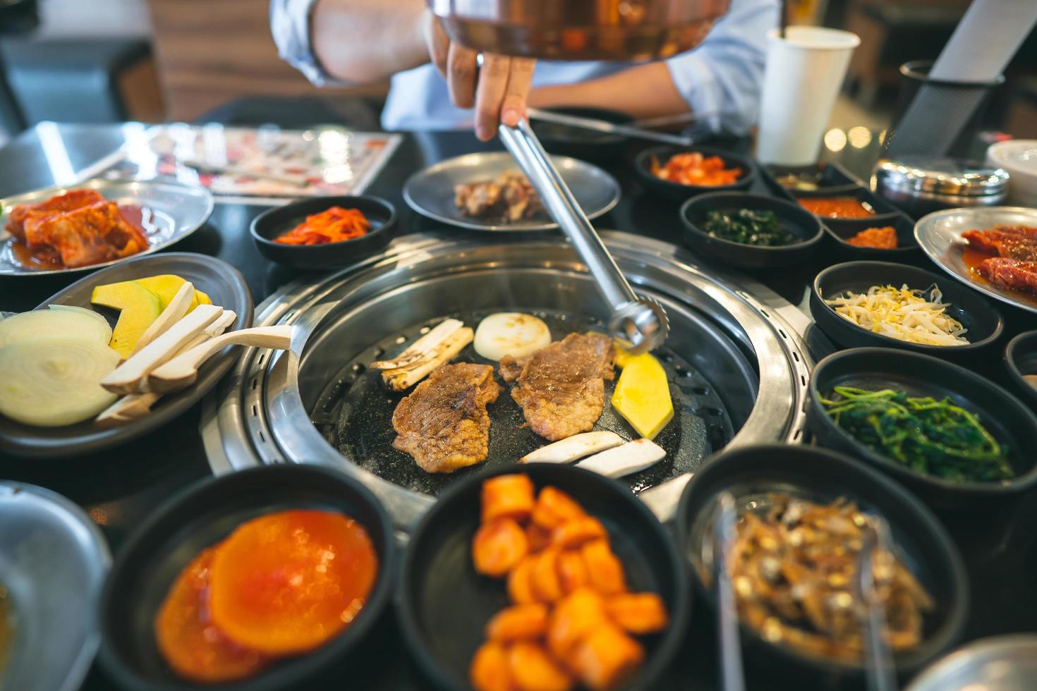 Korea bbq style restaurant  with meat and vegetable side diesh. photo