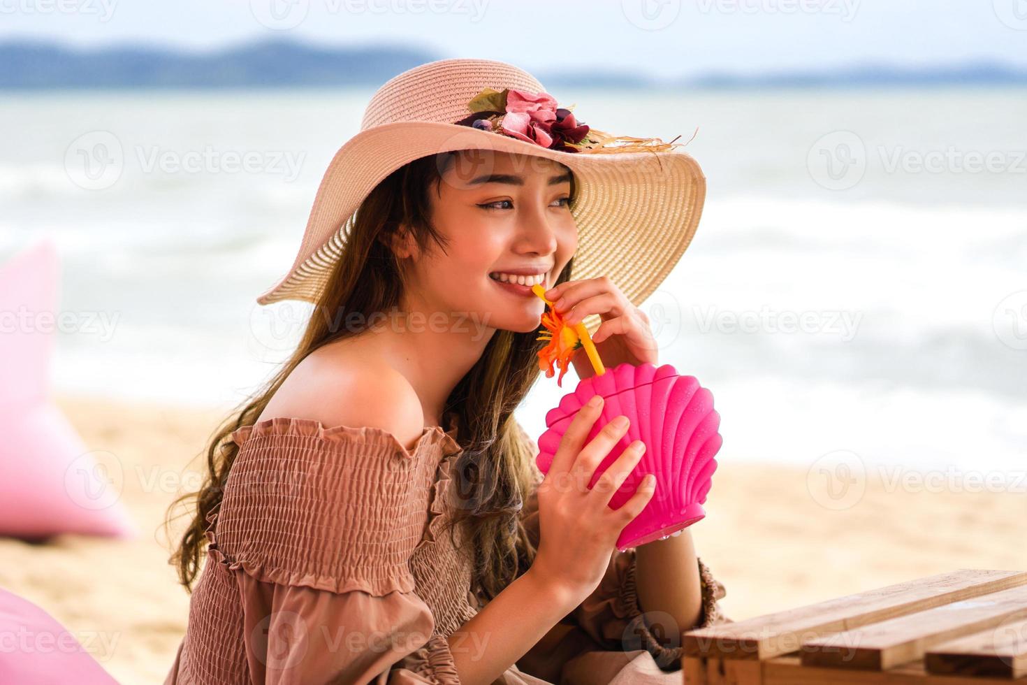 Young woman drink refreshing cocktail relax at beach photo