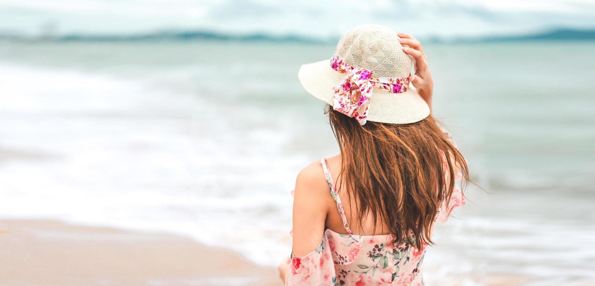 mujer joven asiática caminar y relajarse en la playa foto