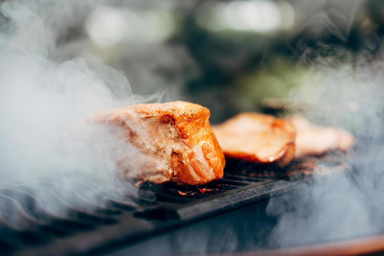 asar a la parrilla en el fuego ahumado en el patio trasero el día foto