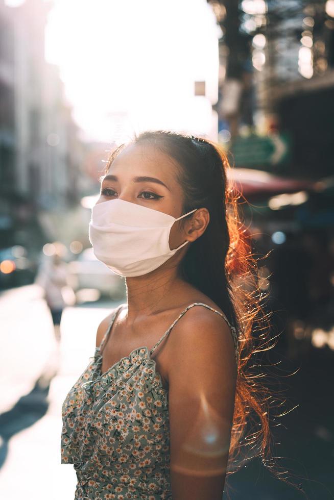 retrato auténtica mujer adulta asiática piel bronceada usar mascarilla para el autocuidado del virus de la corona. foto