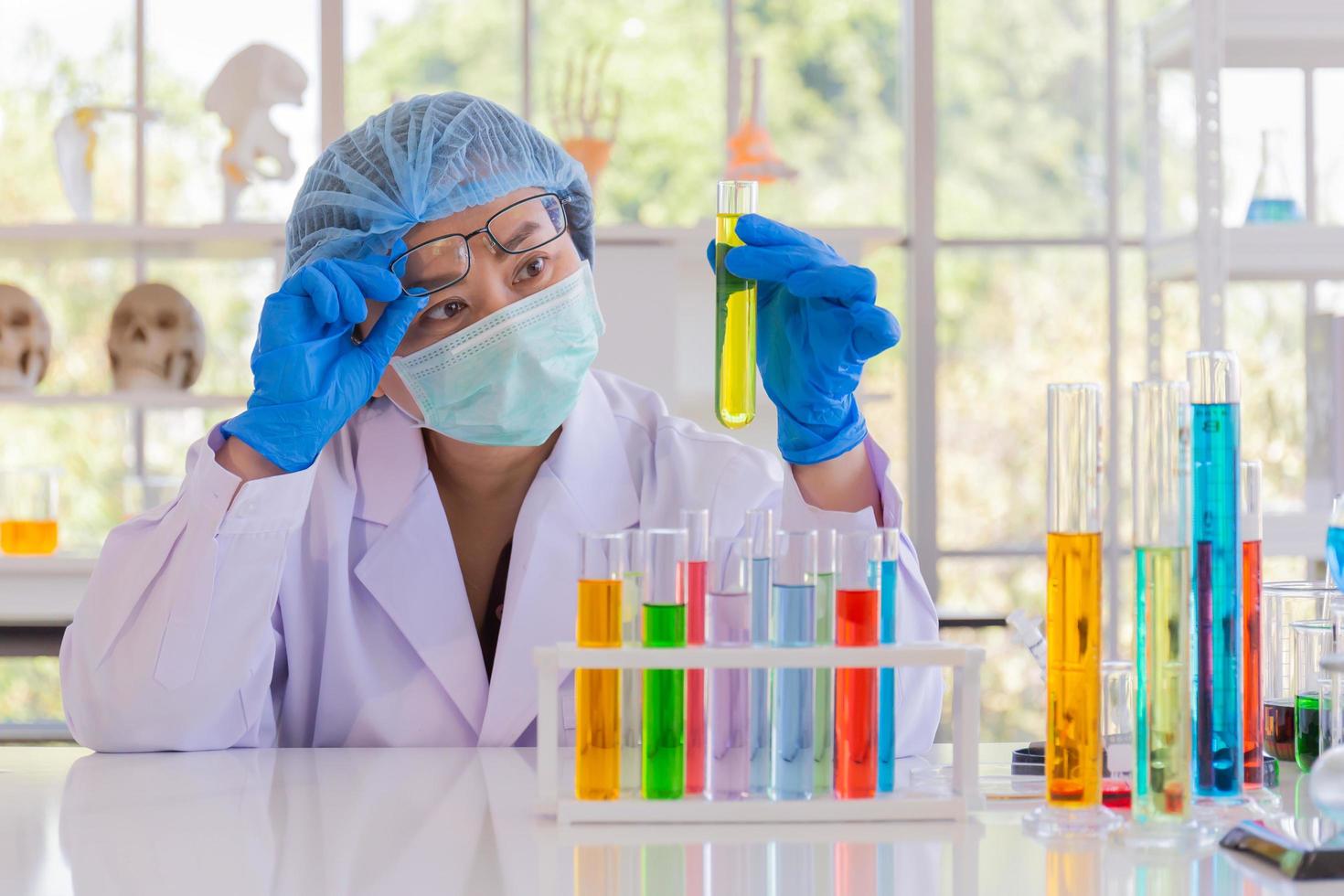 An Asian female scientist is researching a chemical formula in a lab. photo