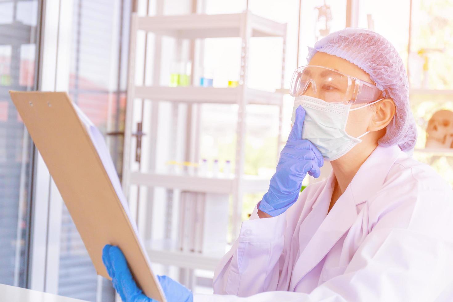 An Asian female scientist is researching a chemical formula in a lab. photo