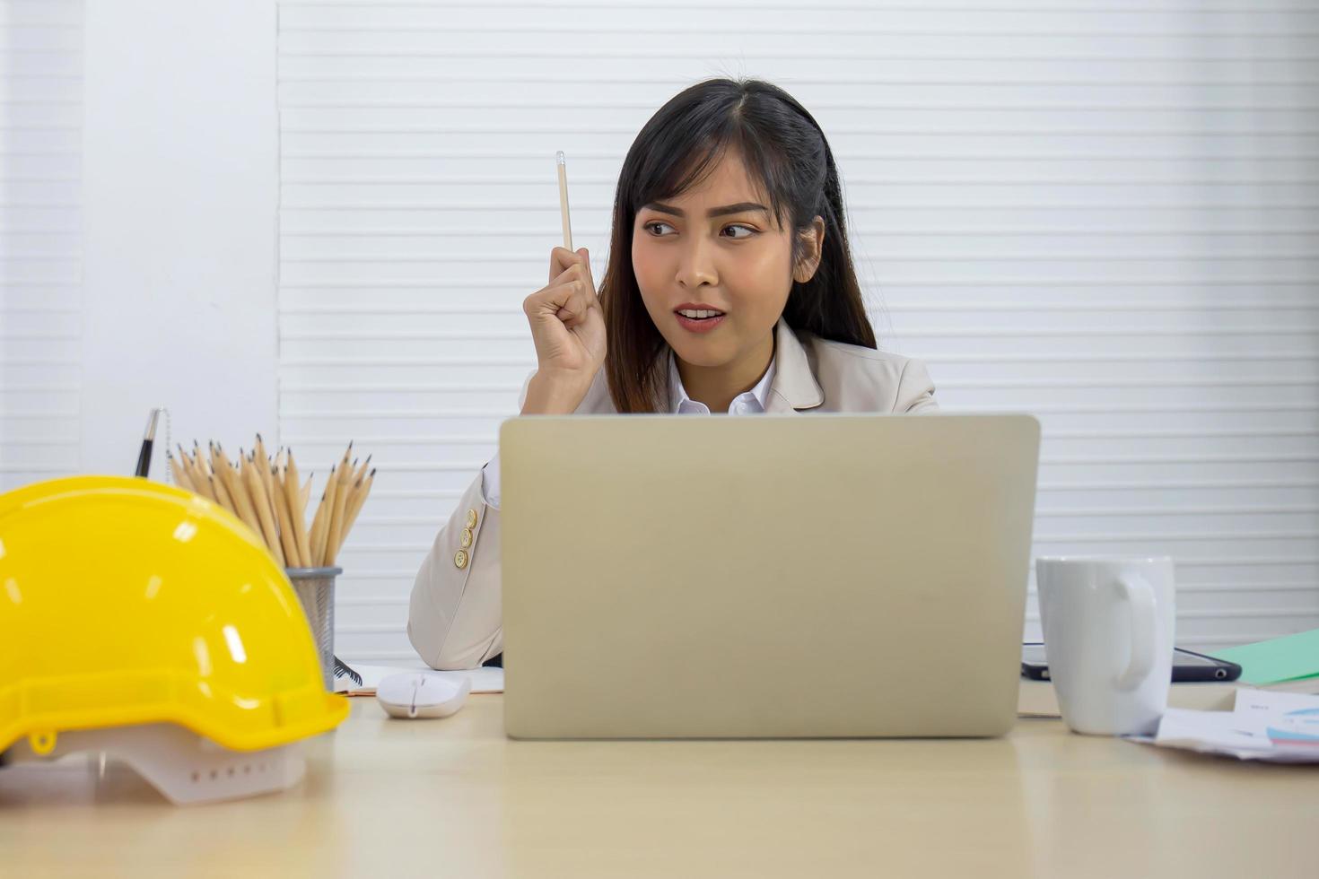 una joven empresaria profesional asiática está durmiendo en su escritorio. foto