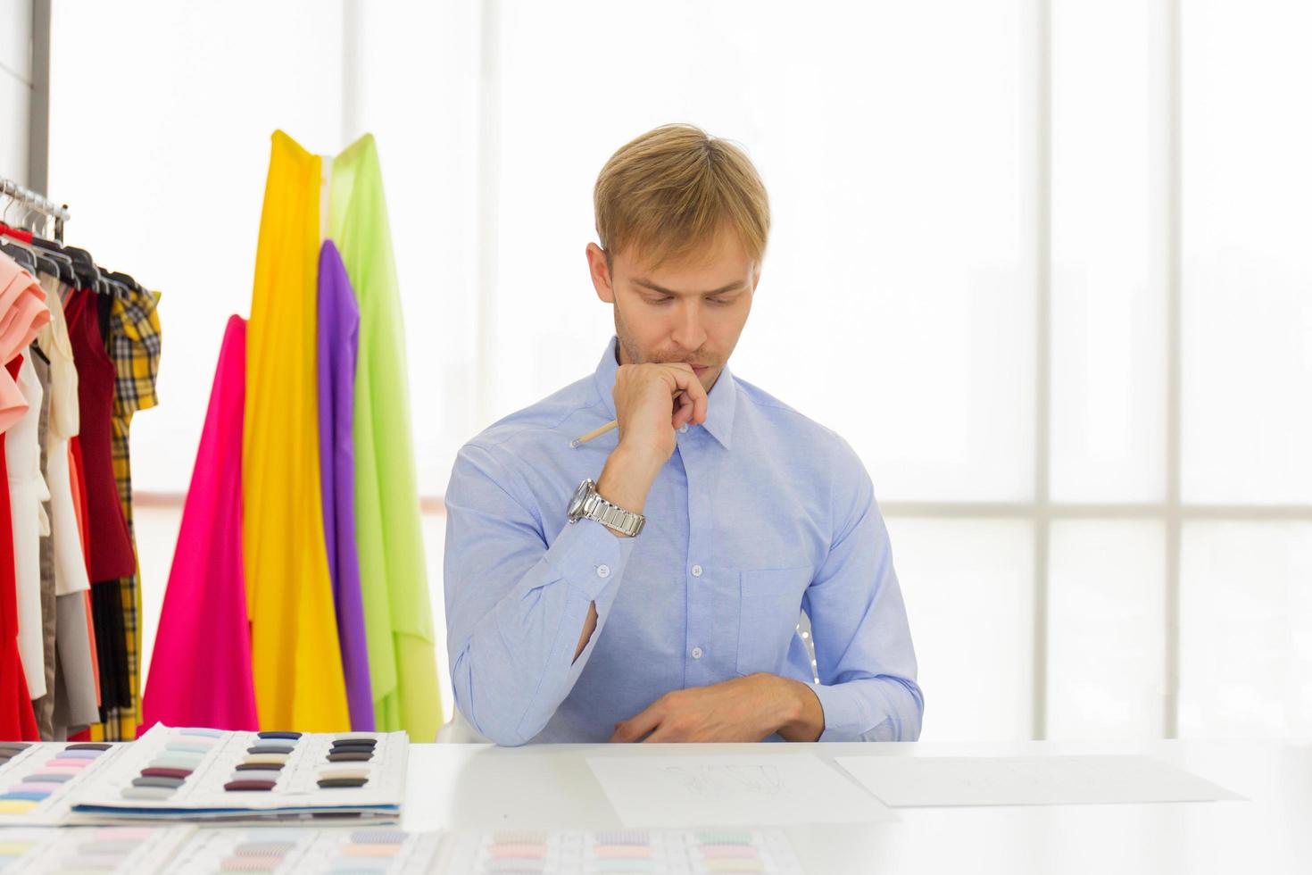 Male designers who are sketching on paper to design clothes photo