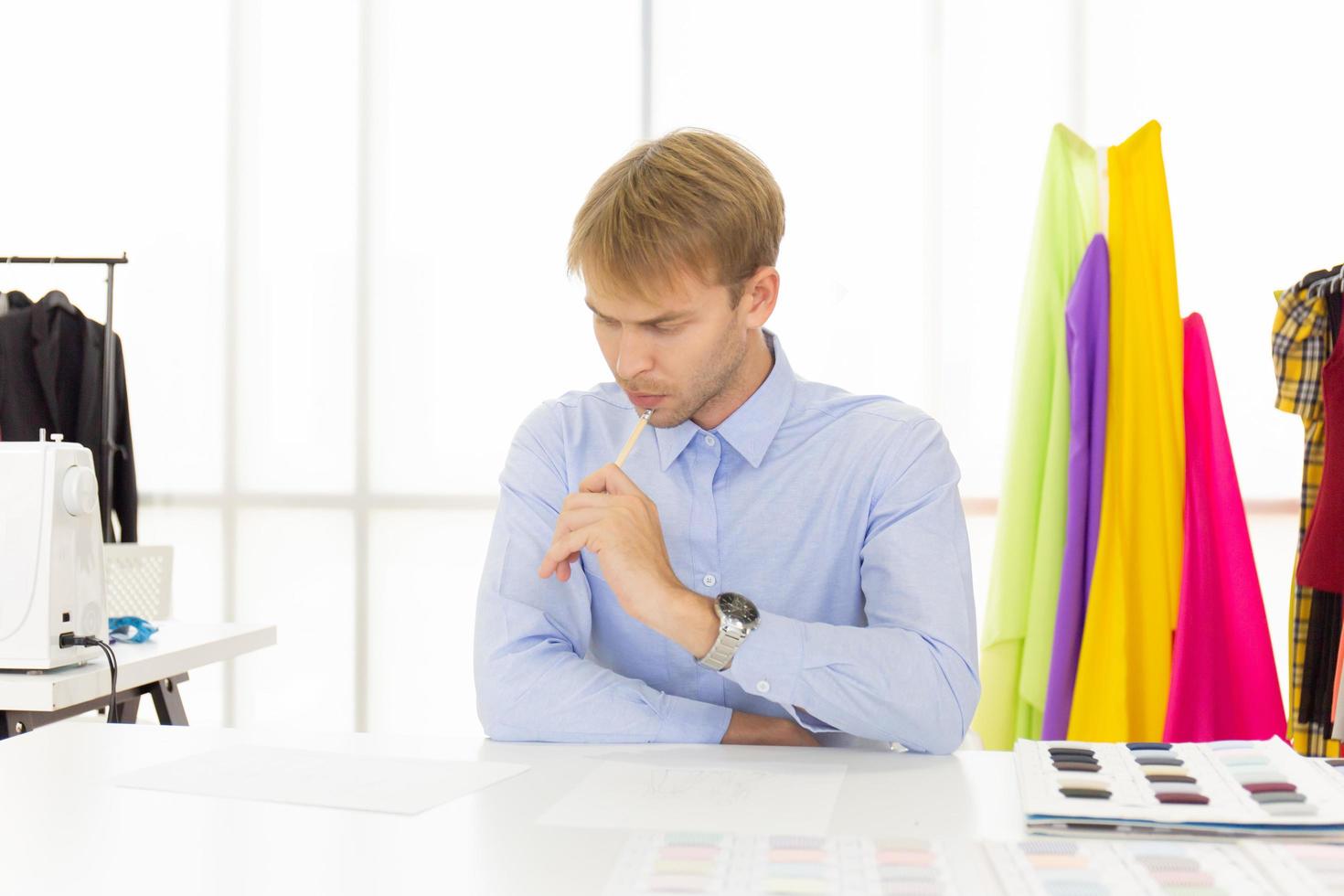 Male designers who are sketching on paper to design clothes photo