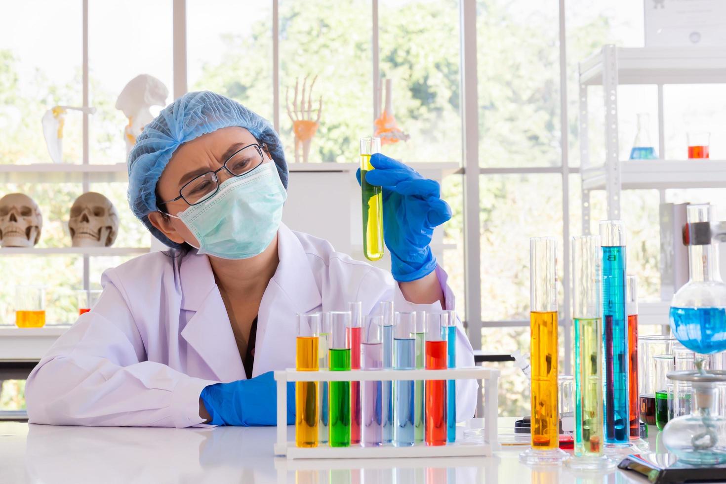An Asian female scientist is researching a chemical formula in a lab. photo