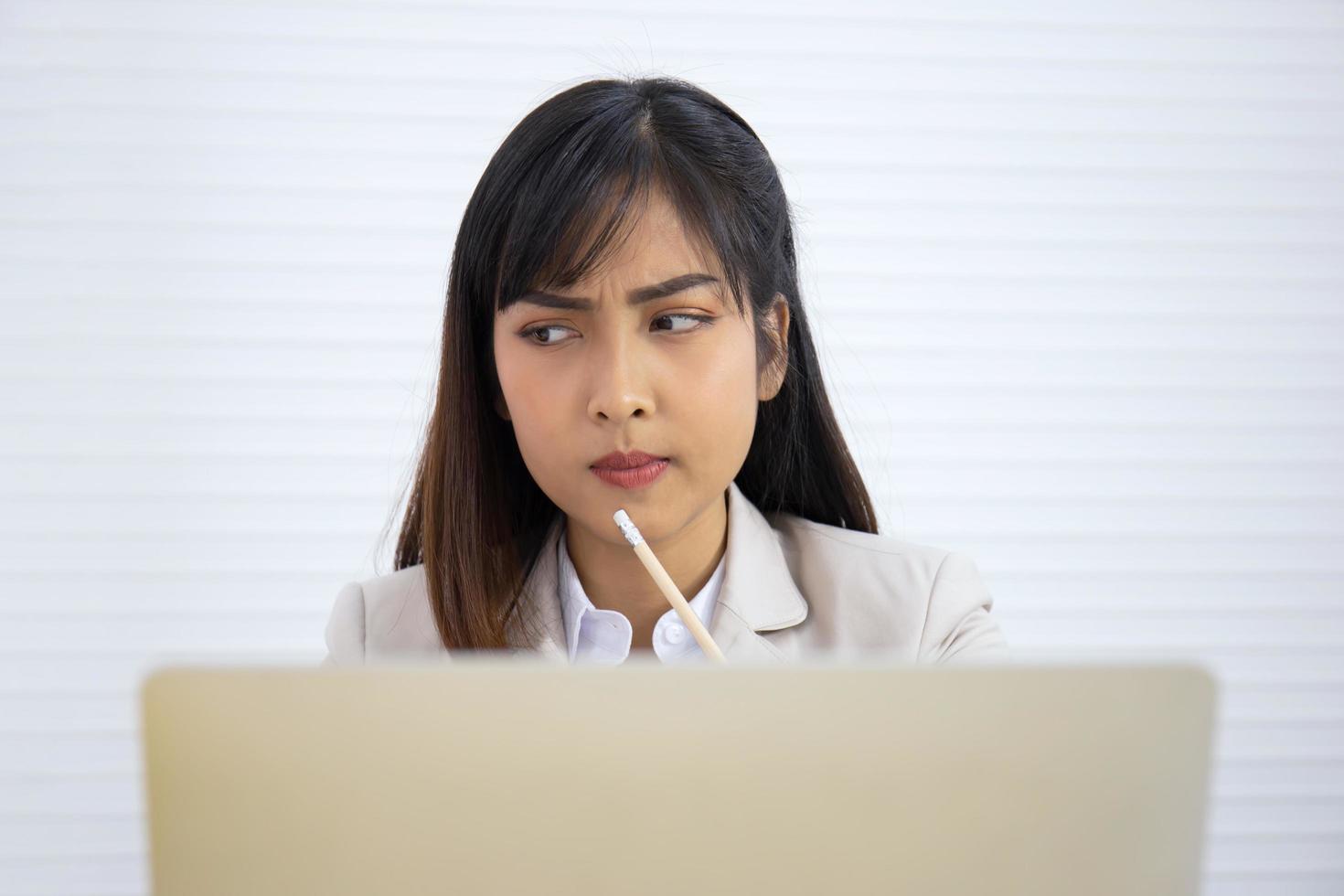 una joven empresaria profesional asiática está durmiendo en su escritorio. foto