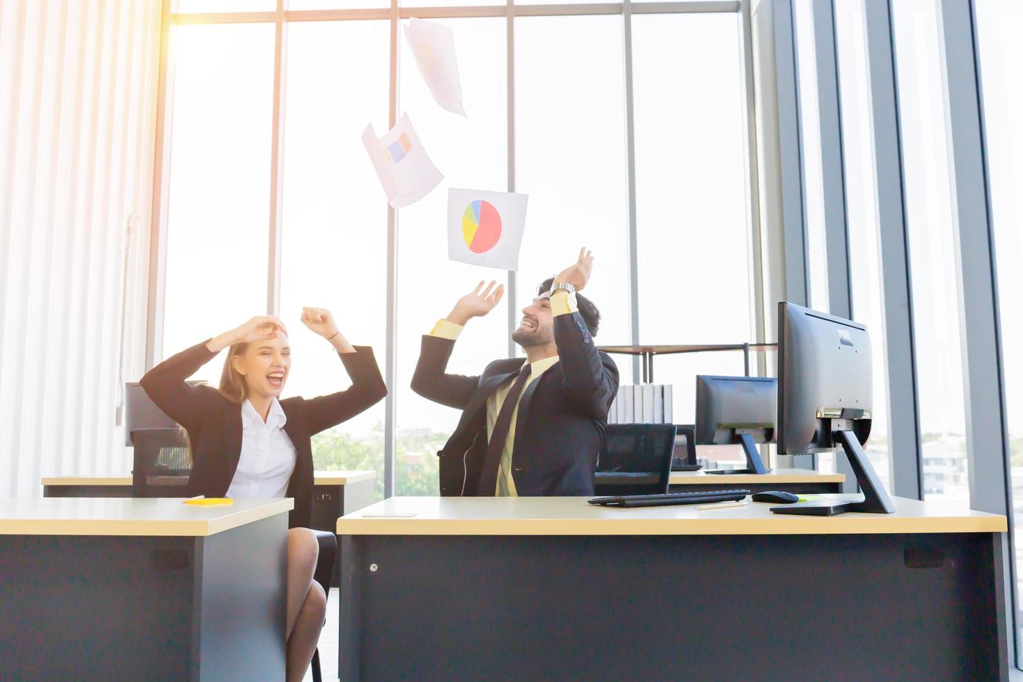 Two young businessmen, men and women, work at the office with a tablet and accompanying documents on the desk with smiles and happiness. photo