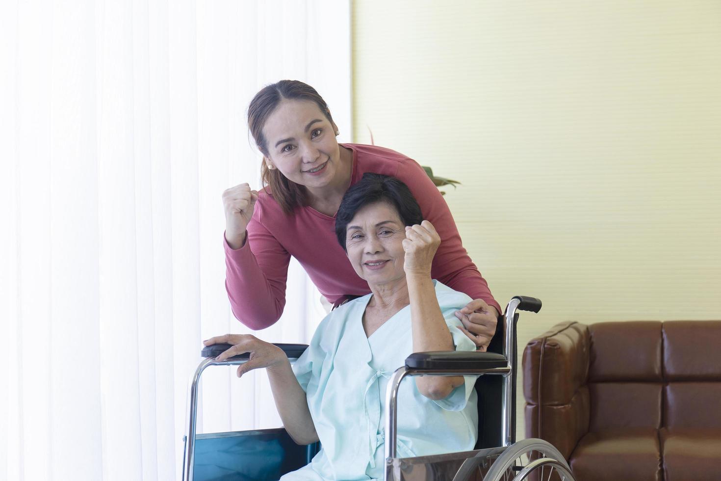 la familia asiática tiene confianza, la madre está enferma, está en silla de ruedas, está hospitalizada y tiene una hija a la que cuidar de cerca. foto