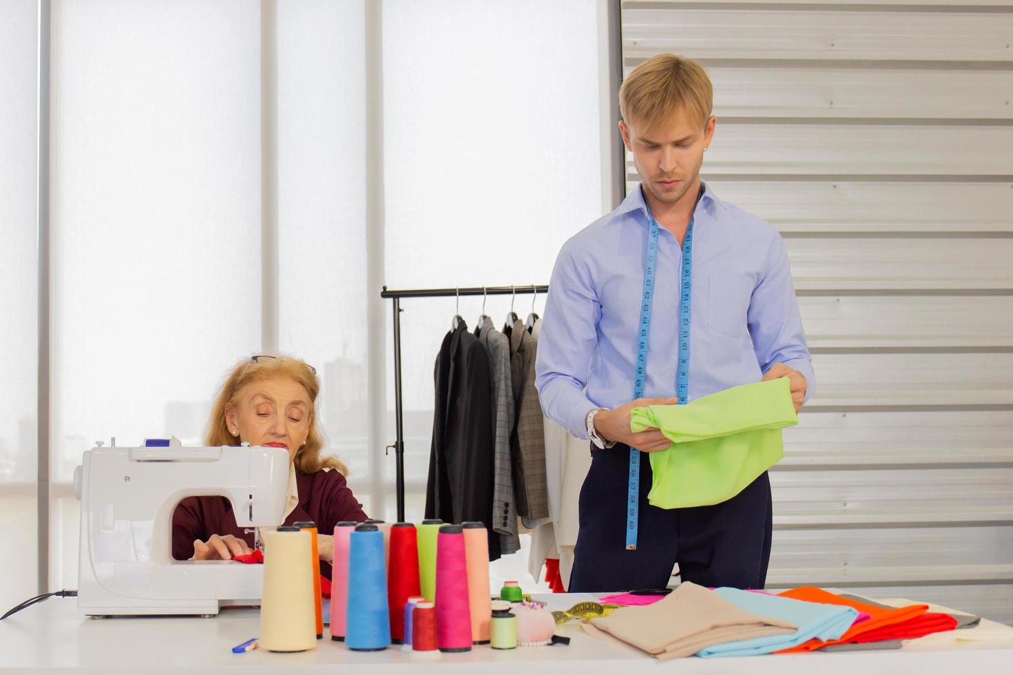 Professional designers, young men and older women in the office with a variety of fabric tones and accessories for various designs. photo