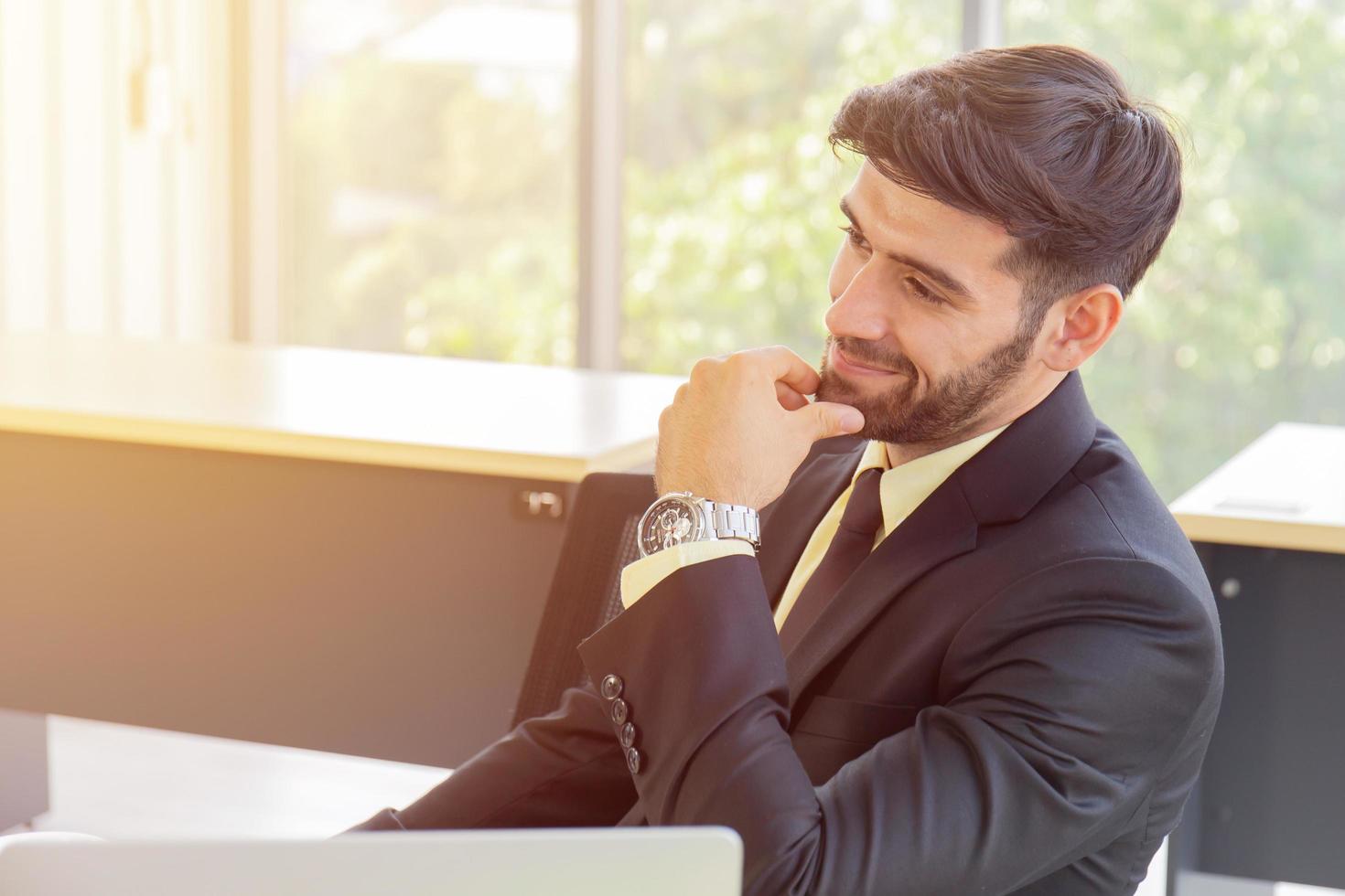 A business man is smiling in the office and has a beautiful orange light. photo