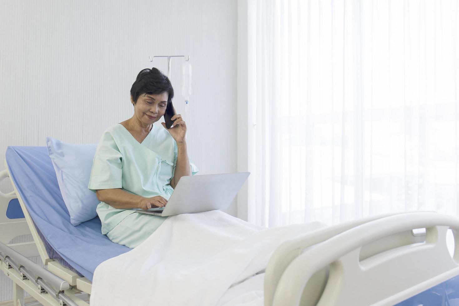 The elderly Asian women sit in bed, recover, talk on the phone, and do errands on laptops, in hospitals, special rooms. photo