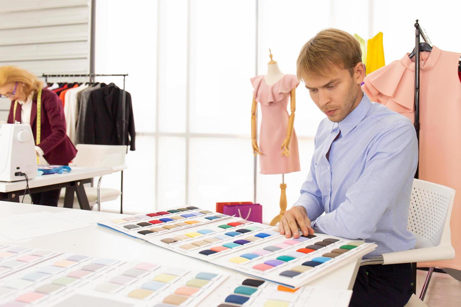 Professional team work designers, young men and elderly women in the office with a variety of fabric tones and equipment for various designs. photo