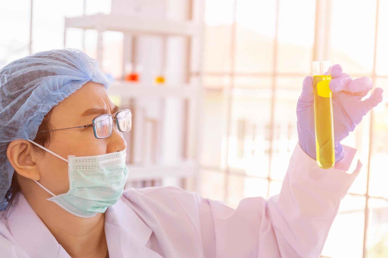 una científica asiática está investigando una fórmula química en un laboratorio. foto