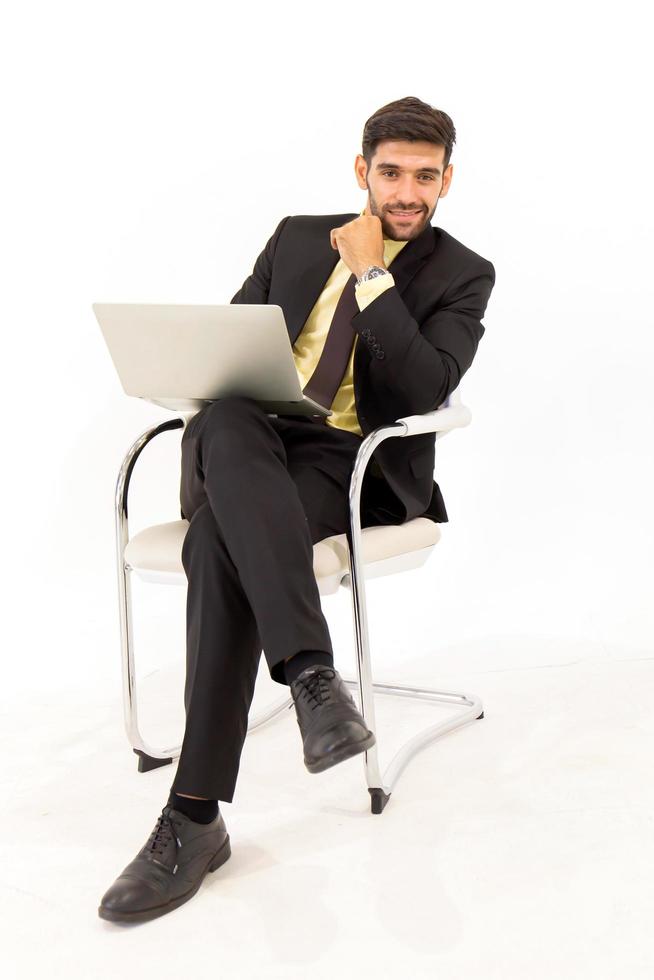 Handsome businessman sitting on a tablet on a metal chair isolated on white background, photo
