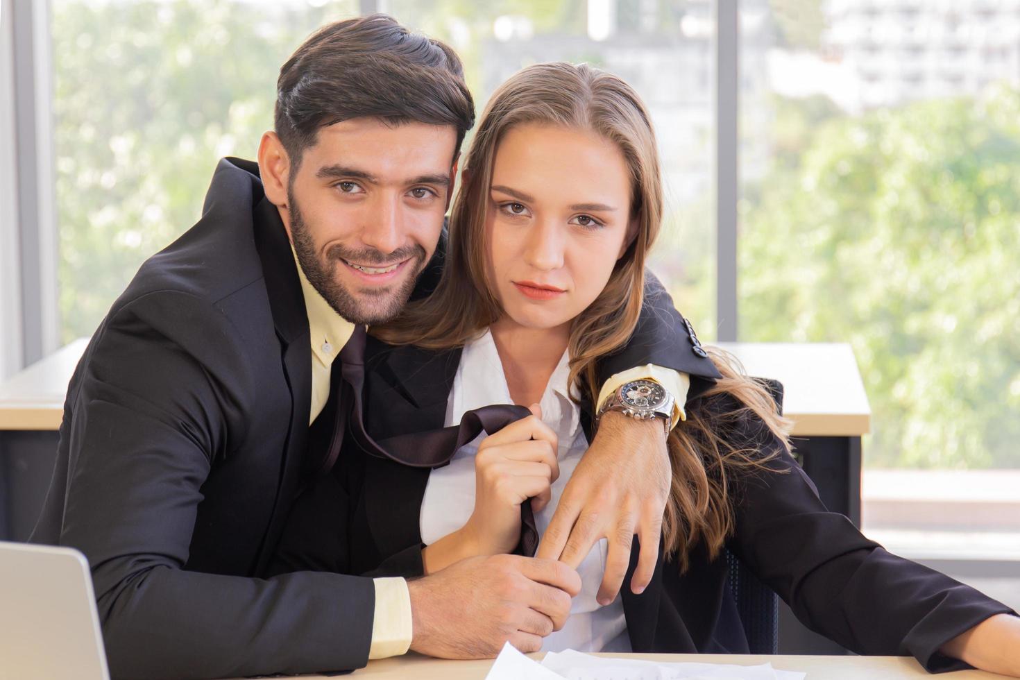 Two young businessmen, men and women, work at the office with a tablet and accompanying documents on the desk with smiles and happiness. photo