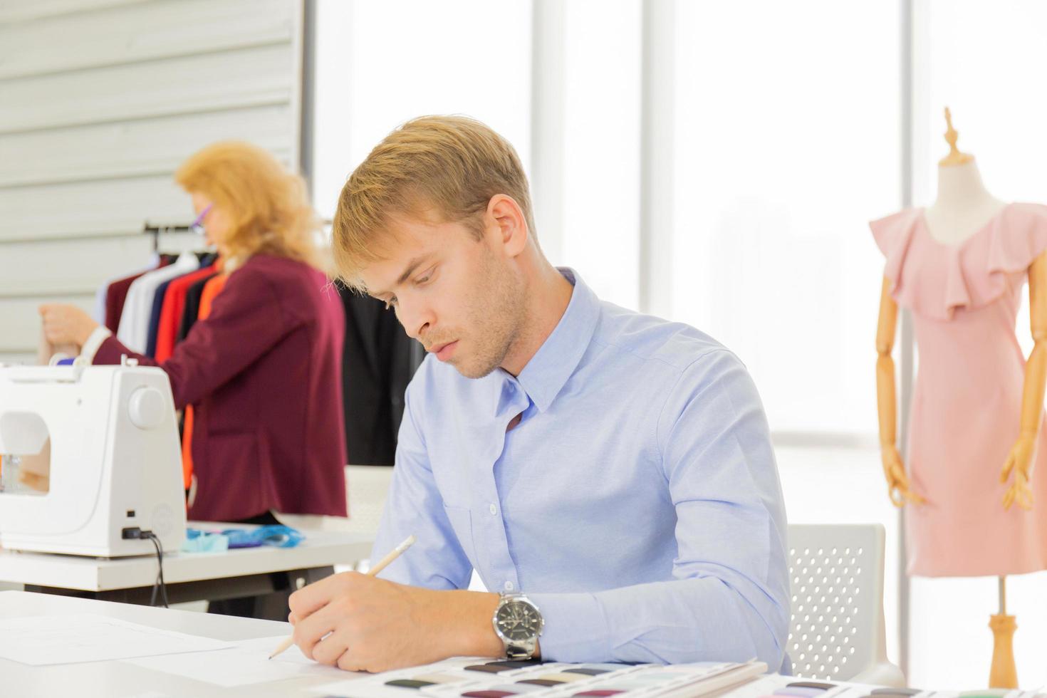 Professional team work designers, young men and elderly women in the office with a variety of fabric tones and equipment for various designs. photo