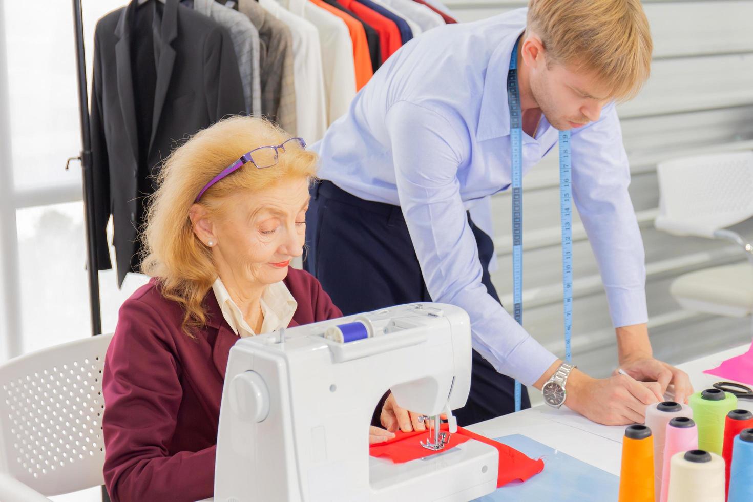 Professional team work designers, young men and elderly women in the office with a variety of fabric tones and equipment for various designs. photo