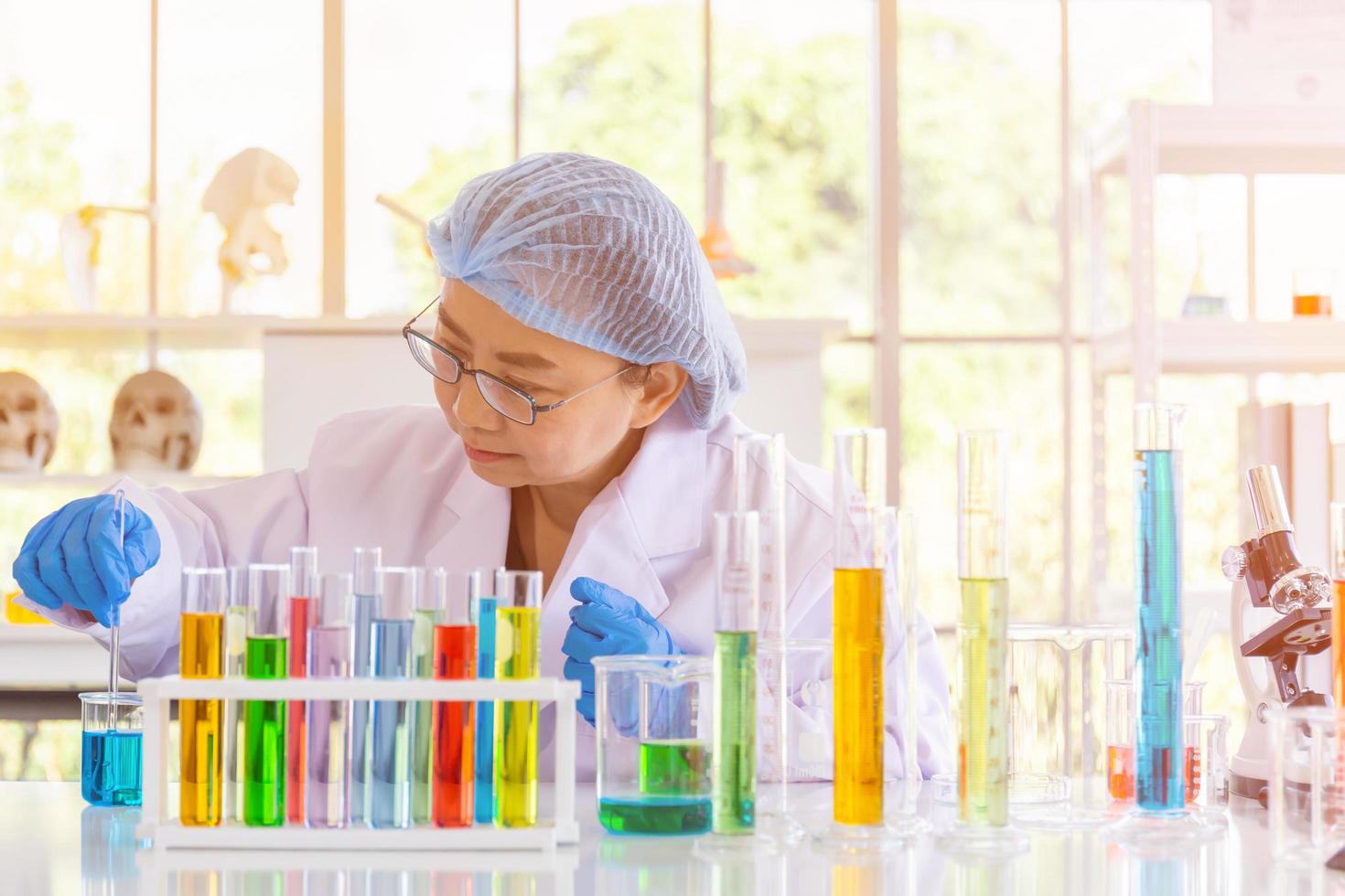 An Asian female scientist is researching a chemical formula in a lab. photo