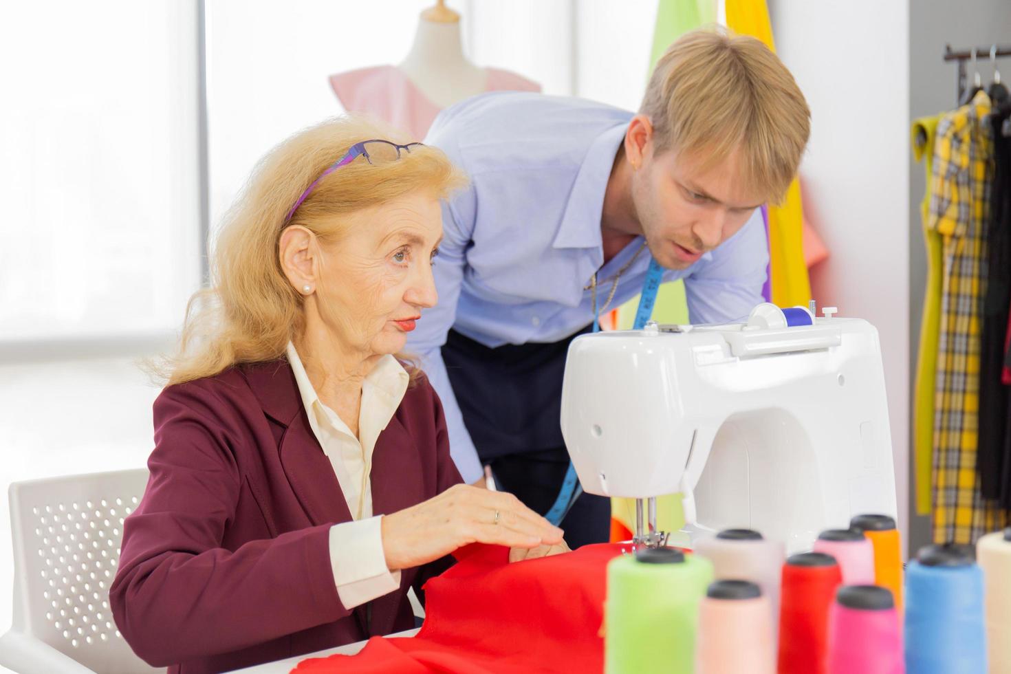 Professional team work designers, young men and elderly women in the office with a variety of fabric tones and equipment for various designs. photo