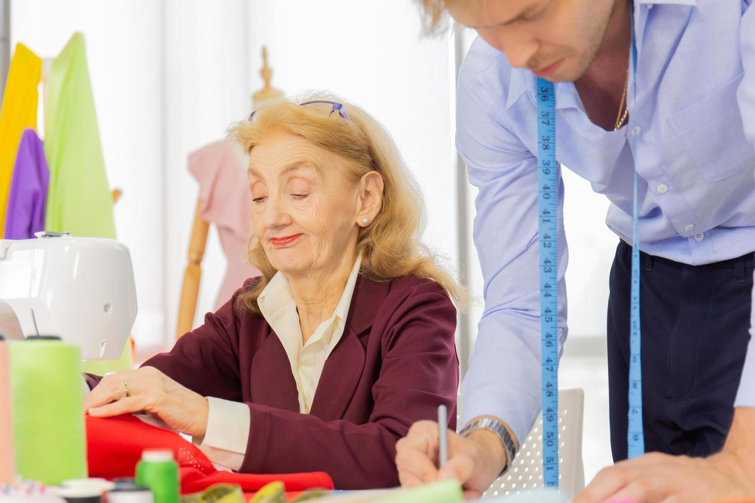 diseñadores profesionales, hombres jóvenes y mujeres mayores en la oficina con una variedad de tonos de tela y accesorios para varios diseños. foto