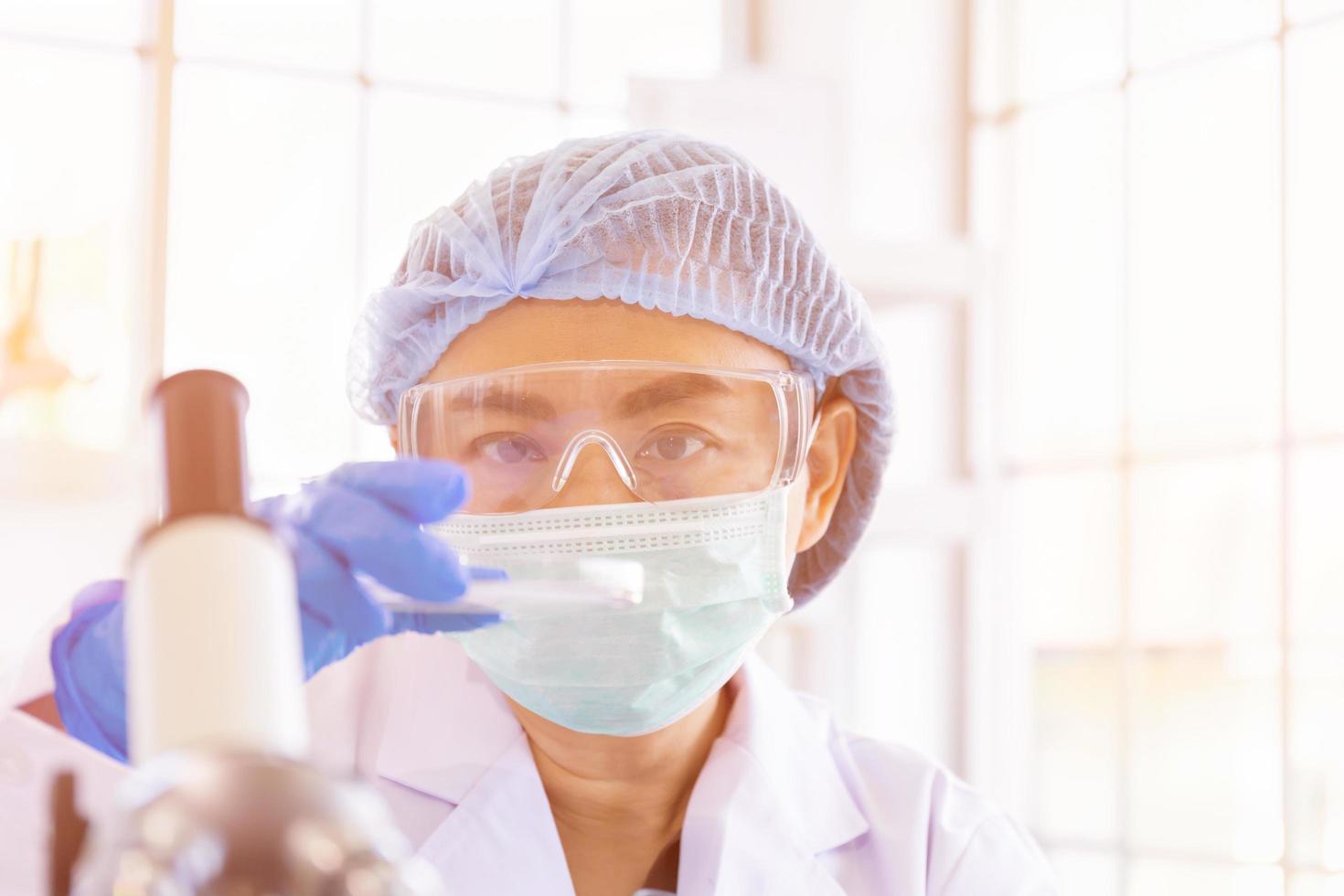 una científica asiática está investigando una fórmula química en un laboratorio. foto