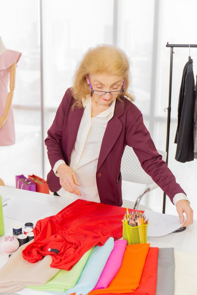 las diseñadoras de costura profesionales en la oficina tienen una variedad de combinaciones de colores de tela. foto