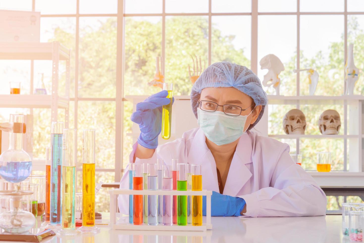 An Asian female scientist is researching a chemical formula in a lab. photo