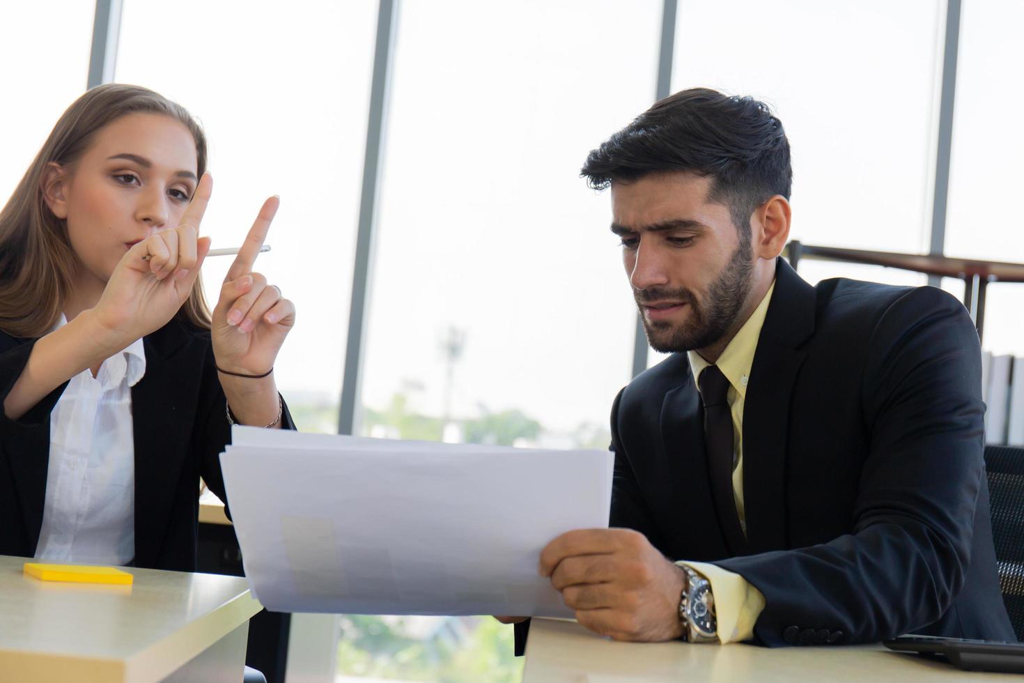 dos jóvenes hombres de negocios, hombres y mujeres, rocío, trabajan en la oficina con seriedad. foto