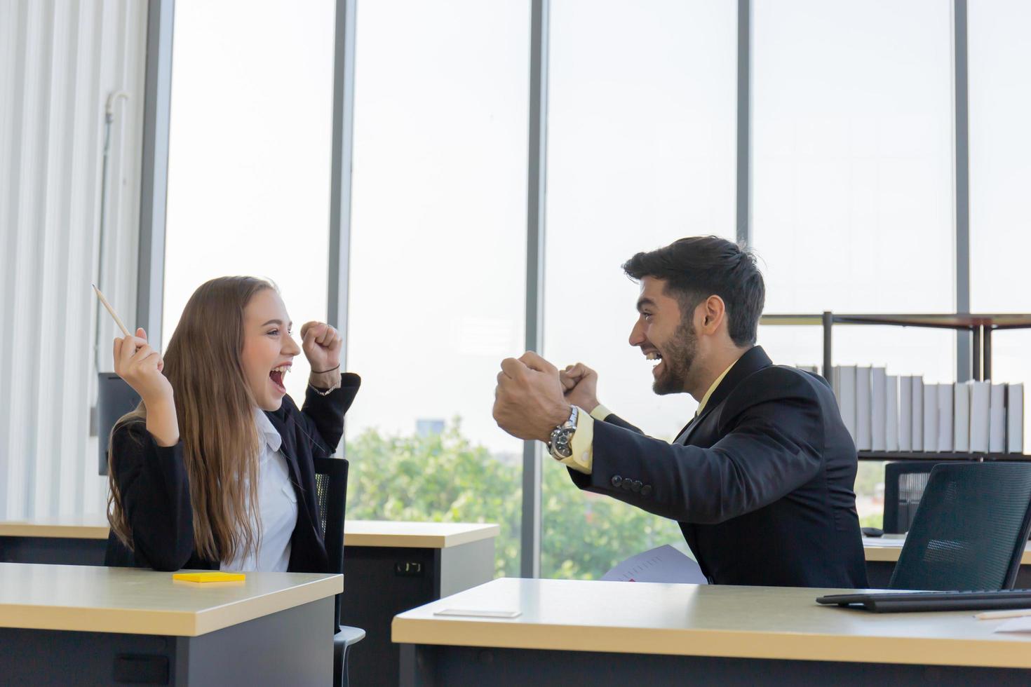 Two young businessmen, men and women, who showed great joy at the office with smiles and happiness. photo