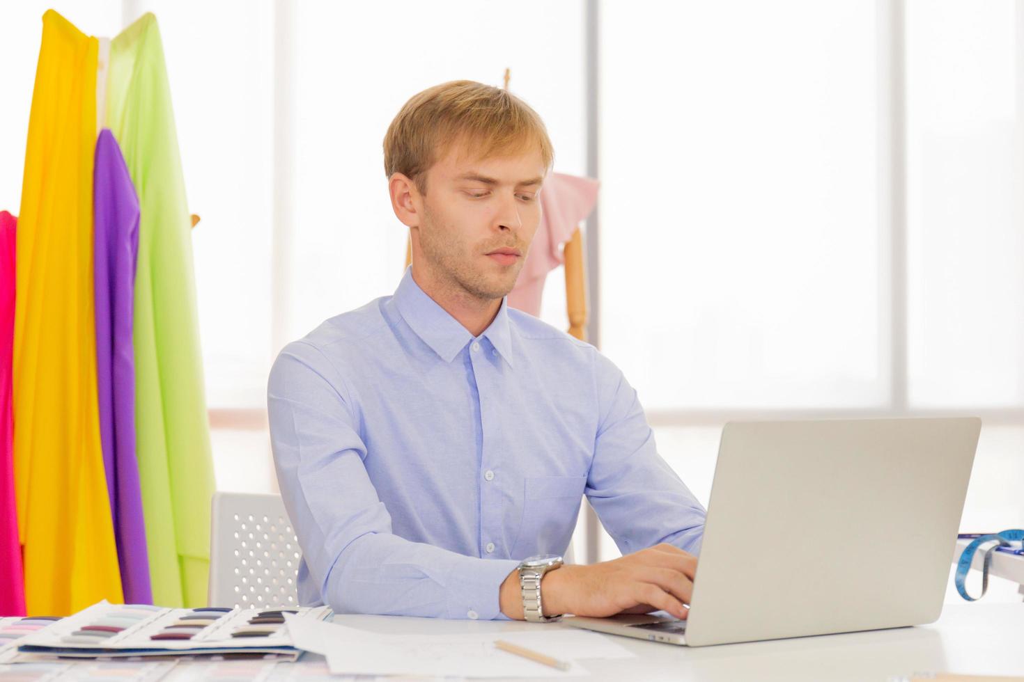 Professional male sewing designers in the office have a variety of fabric color schemes. photo