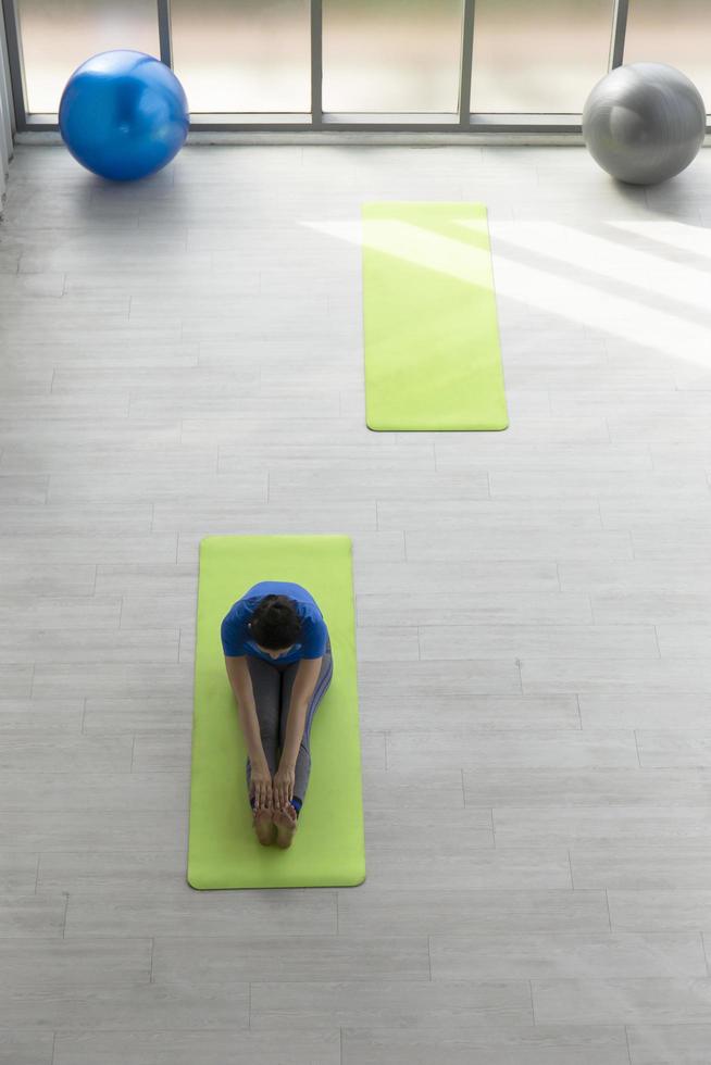 Top view corner, a woman doing yoga in the gym. photo