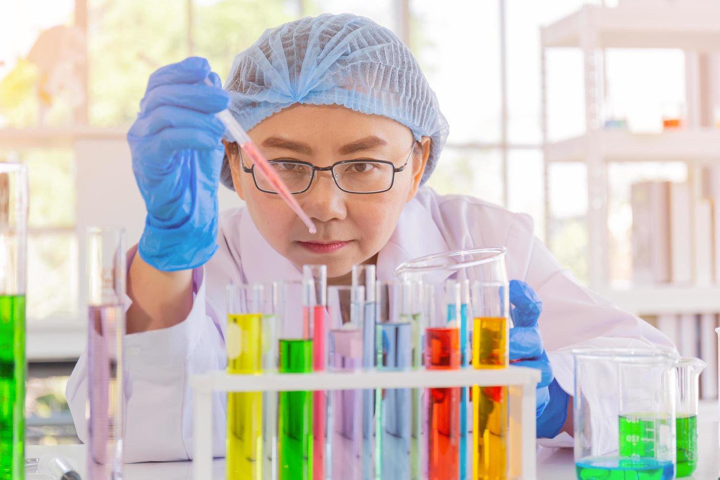 An Asian female scientist is researching a chemical formula in a lab. photo