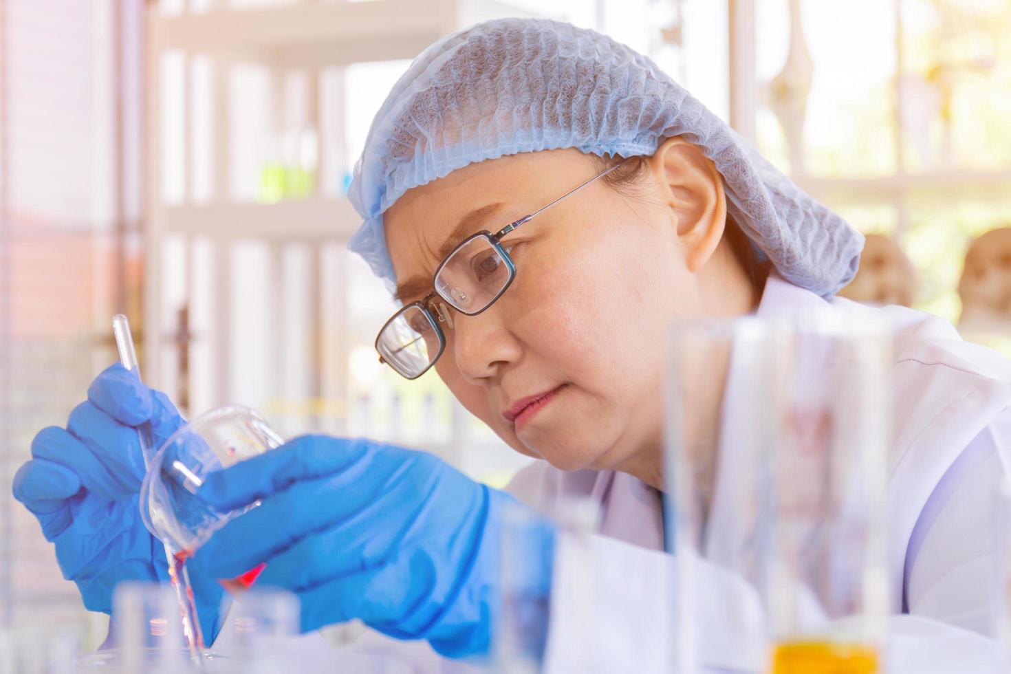 una científica asiática está investigando una fórmula química en un laboratorio. foto