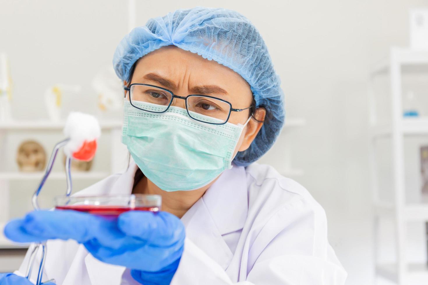 una científica asiática está investigando una fórmula química en un laboratorio. foto