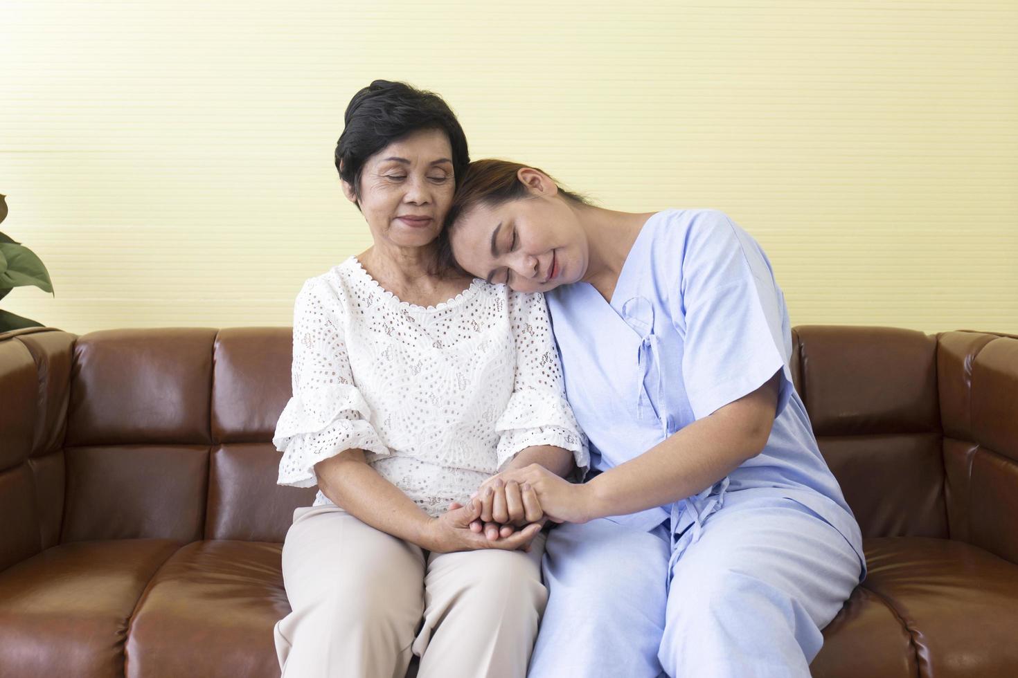 The Asian daughter who was sick in the hospital had her mother beside her to support and sat on the sofa in a special room. photo