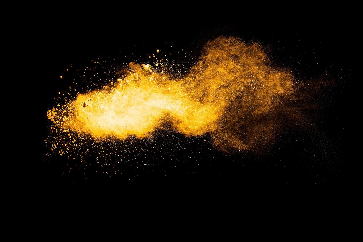 Orange color powder explosion on black background. photo