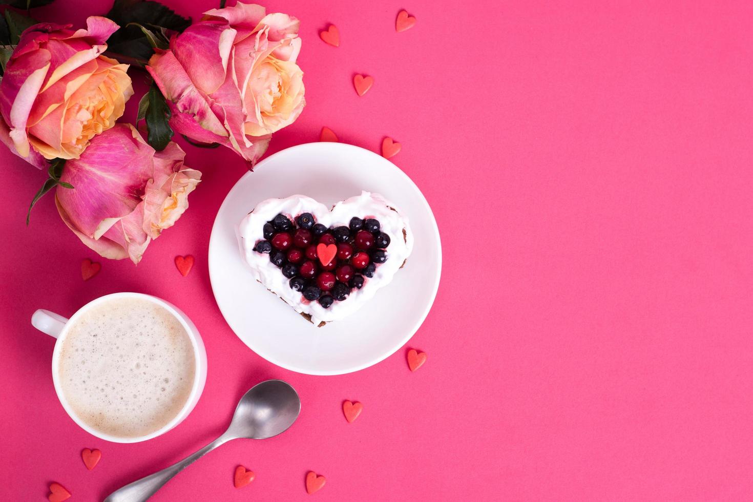 Heart shaped cake decorated with red currant on pink back photo
