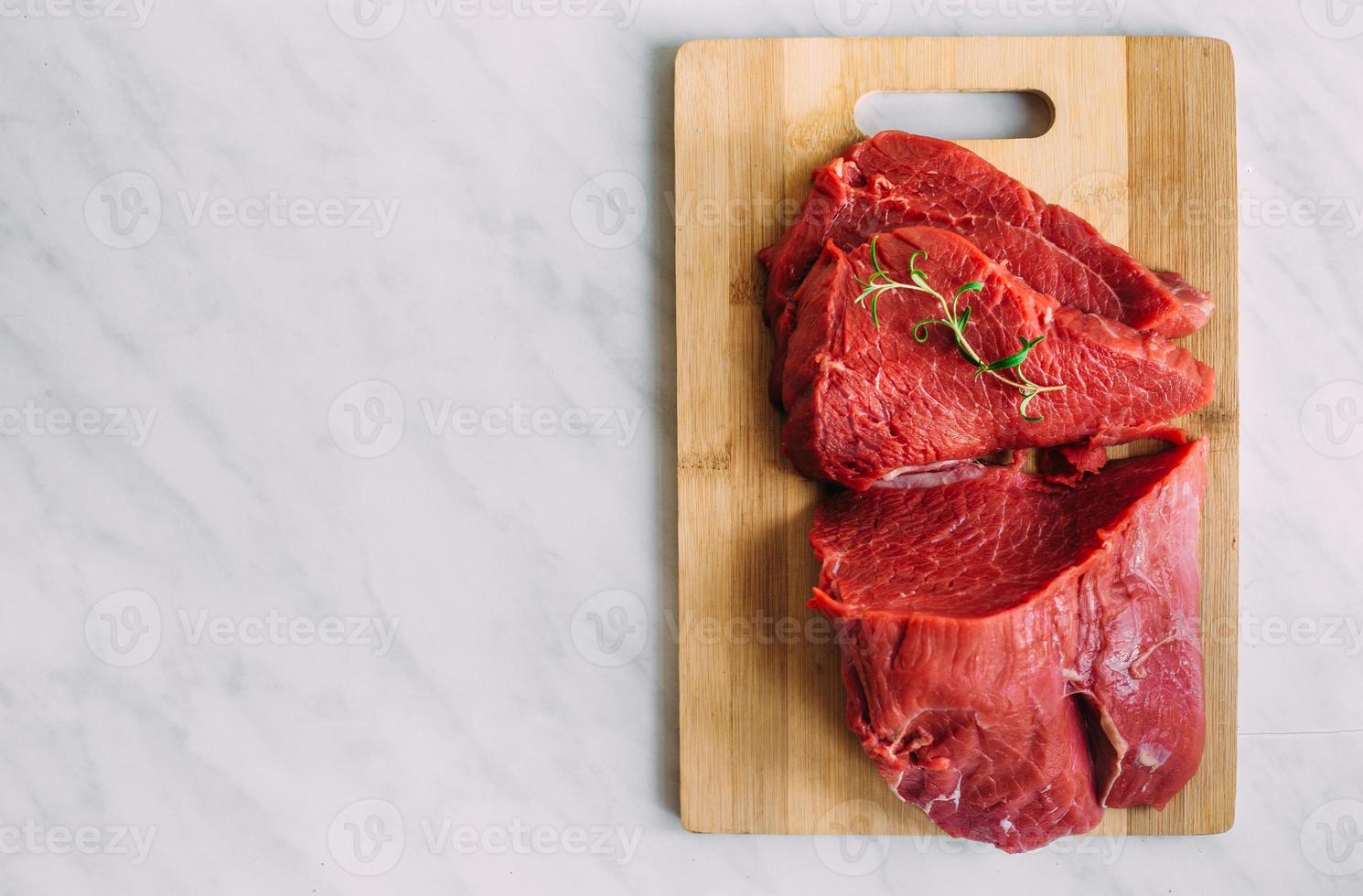 filete crudo de cerdo fresco sobre tabla de madera. carne de res roja en una tabla de cortar. foto